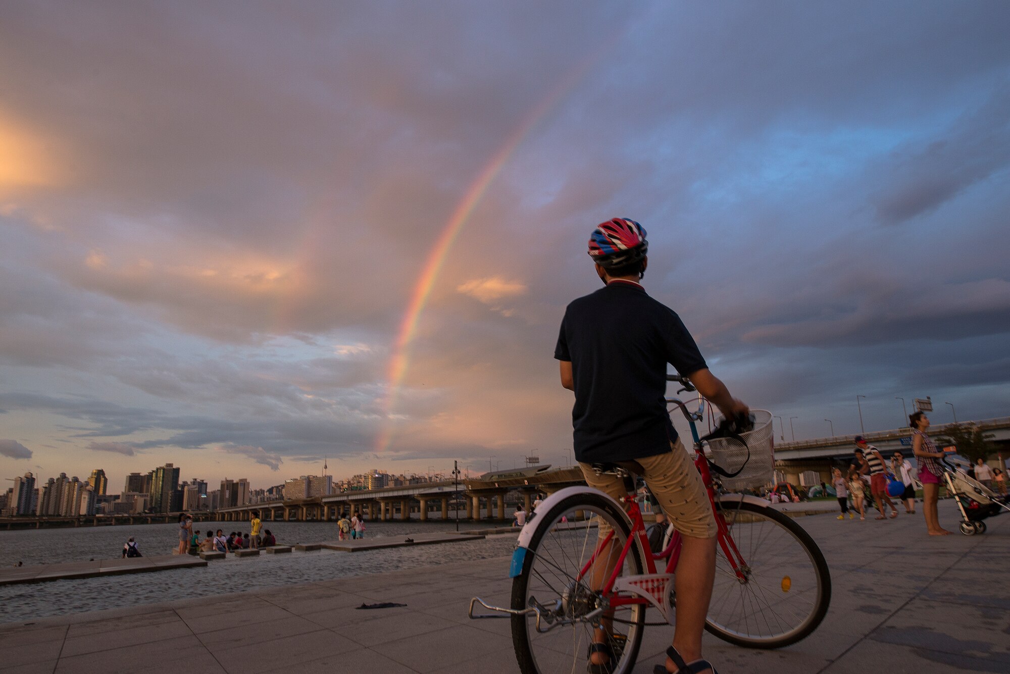 A cyclist admires a double rainbow over the Han River Aug. 2, 2014, in Seoul, Republic of Korea. The park on the front of the Han River is a popular evening and weekend destination in Seoul. (U.S. Air Force photo by Staff Sgt. Jake Barreiro)