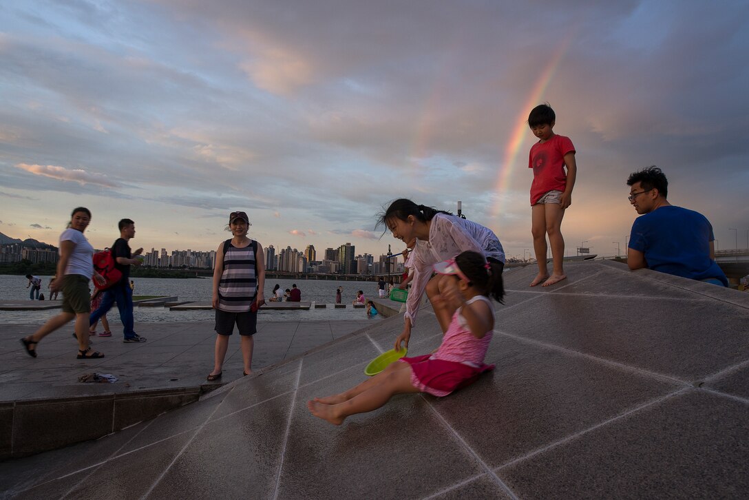 Children slide down the sides of a public fountain in Yeouido Park Aug. 2, 2014, in Seoul, Republic of Korea. The fountain is often used in the summertime by children to cool off and play games. (U.S. Air Force photo by Staff Sgt. Jake Barreiro)