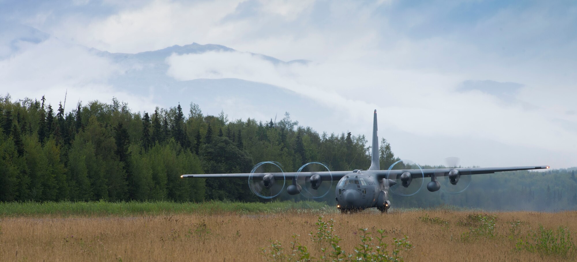 A C-130 Hercules from the 36th Airlift Squadron takes off from a secondary landing zone on Joint Base Elmendorf-Richardson, Alaska, Aug. 5, 2014. The LZ gives pilots a chance to experience a dirt runway. (U.S. Air Force photo by Staff Sgt. Chad C. Strohmeyer/Released)