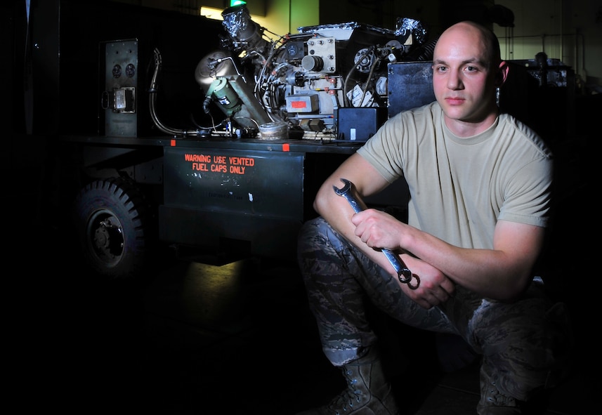 U.S. Air Force Staff Sgt. Devon Brown, 35th Maintenance Squadron aerospace ground equipment craftsman, poses in front of gas turbine engine at Misawa Air Base, Japan, Aug. 7, 2014. Brown is entrusted with inspecting, repairing, and servicing 500 pieces of aerospace ground equipment. (U.S. Air Force photo/Senior Airman Jose L. Hernandez-Domitilo)