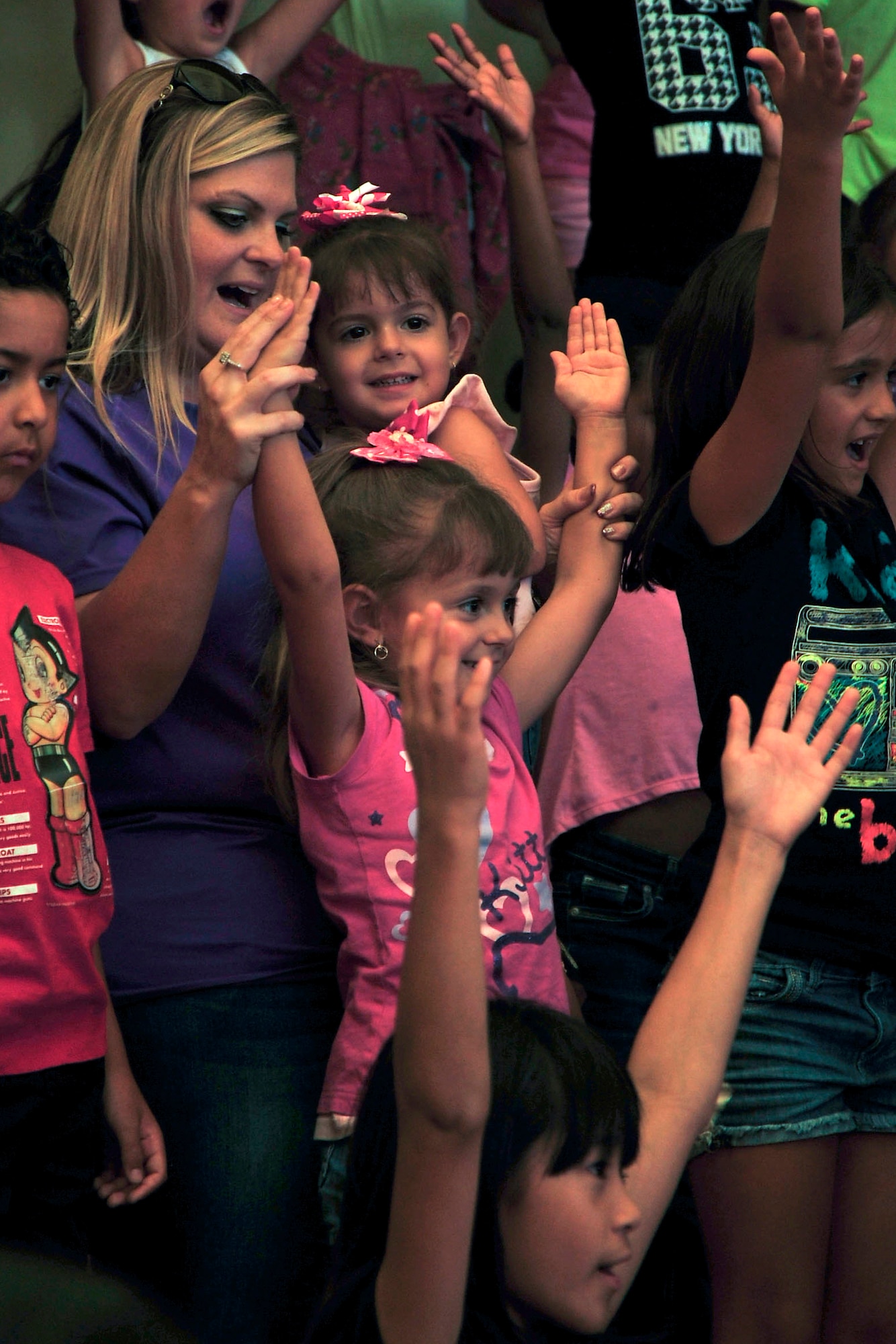 The audience sings along to “Y.M.C.A.” during a Tops in Blue performance at the Youth Center on Andersen Air Force Base, Guam, Aug. 7, 2014. The Tops in Blue crew spent the day putting on shortened performances at the dining facility, the Exchange and the Youth Center in addition to their main show performed for the whole base the prior evening as part of their 2014 “Celebrating 60 Years of Tradition” tour. (U.S. Air Force photo by Staff Sgt. Melissa B. White/Released)