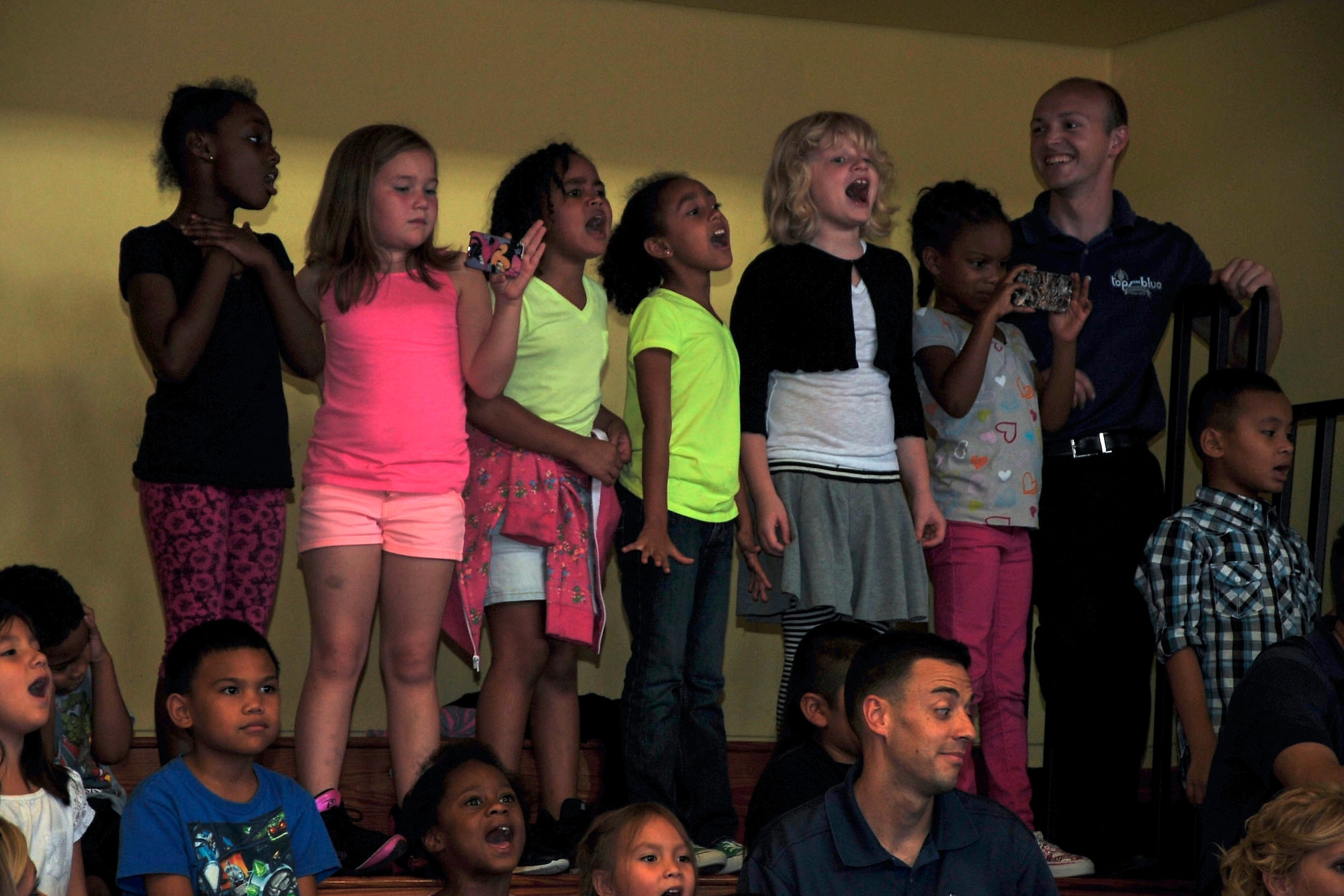 Team Andersen children sing along to “Let It Go” during a Tops in Blue performance at the Youth Center on Andersen Air Force Base, Guam, Aug. 7, 2014. The Tops in Blue crew spent the day putting on shortened performances at the dining facility, the Exchange and the Youth Center in addition to their main show performed for the whole base the prior evening as part of their 2014 “Celebrating 60 Years of Tradition” tour. (U.S. Air Force photo by Staff Sgt. Melissa B. White/Released)