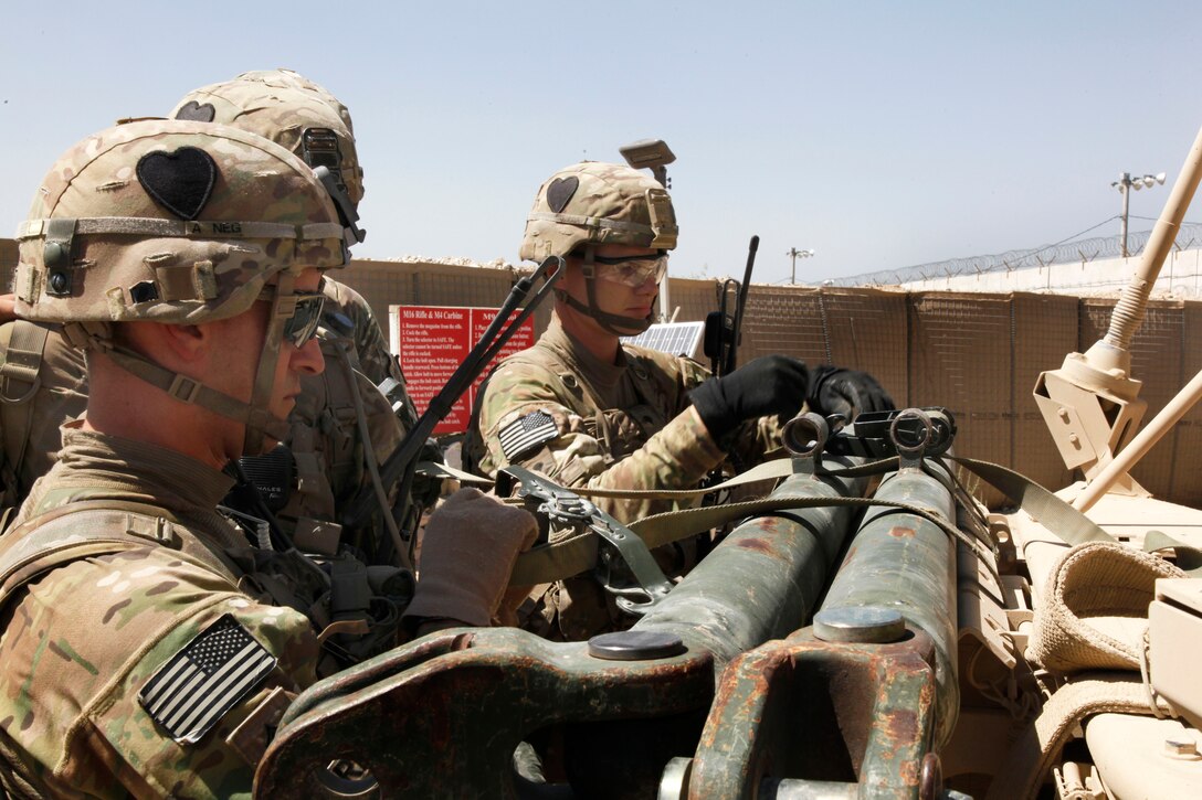 U.S. soldiers tie a tow bar to the front of a vehicle on Bagram Airfield in Afghanistan's Parwan province, Aug. 11, 2014.