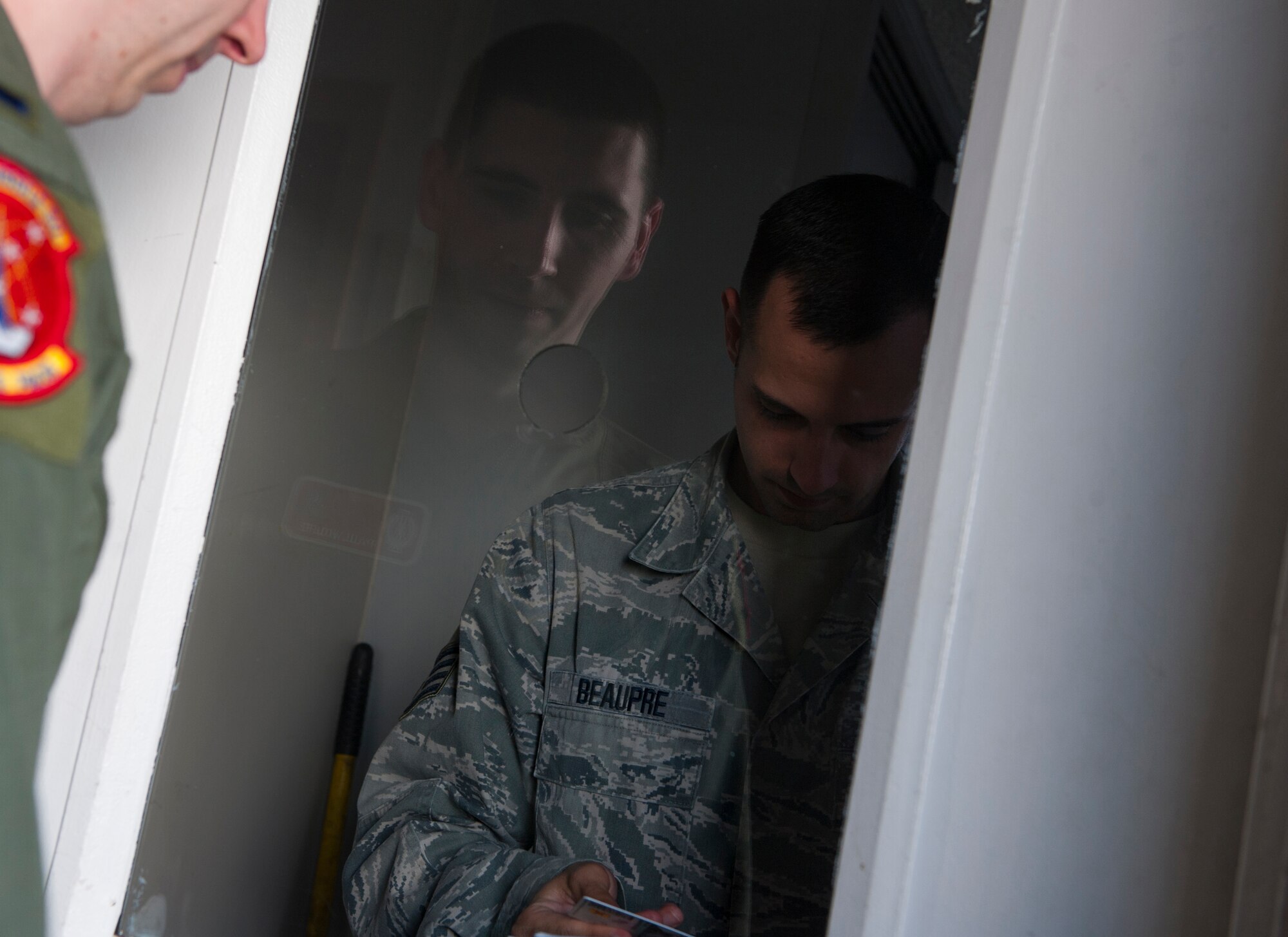 Staff Sgt. Timothy Beaupre checks the identification card of 1st Lt. Paul Wolfe July 30, 2014, before he enters the control room at a Missile Alert Facility in North Dakota. During code change, missileers work 12-hour shifts instead of the usual 24-hour shifts due to an increase in the mission tempo. Beaupre is a 91st Missile Security Forces Squadron flight security controller and Wolfe is the 740th Missile Squadron missile combat crew commander. (U.S. Air Force photo/Airman 1st Class Apryl Hall)
