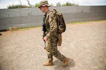 MARINE CORPS TRAINING AREA BELLOWS, Hawaii – Cpl. Ryan Ill, a squad leader with first platoon Kilo Company, 3rd Battalion, 3rd Marine Regiment, and a native of Millington, Mich., dons the Foot Mobile Charger (FMC) at Marine Corps Training Area Bellows, July 13. The FMC is an attachable battery that can be intertwined with an assault pack or flak jacket and recharges other types of batteries, distributing more energy across the battlefield. It also has a solar panel attachment that can be used to recharge the main battery. The FMC is part of the Marine Corps Advanced Warfighting Experiment, a culmination of progressive experiments designed to test potential future technologies, solutions and concepts to future Marine Air Ground Task Force challenges. (U.S. Marine Corps photo by Cpl. Matthew J. Bragg)