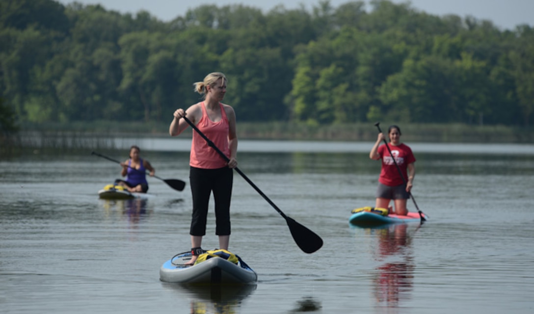 From left to right, Sonia Cazarez, Tami Imlay and Leigh Giglio practice maneuvering paddleboards Aug. 1, 2014, on the calm water of Holbrook Lake, Minn. The women were participated in the retreat for widows of U.S. military members who lost their lives while serving their country. The Holbrook Farms Retreat is hosted by husband and wife Lt. Cols. Matthew and Micaela Brancato, both assigned to the North Dakota Air National Guard’s 119th Wing. (U.S. Air Force photo/Senior Master Sgt. David H. Lipp)