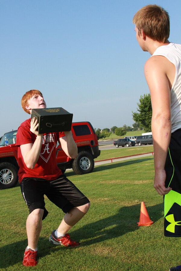 A player with Ardmore High School football team, lifts an ammo can while conducting the Marine Corps Combat Fitness Test, at Ardmore High School, OK, Aug. 4, 2014. Ardmore coaching staff invited the Marines of Recruiting Sub Station Denton to discuss teamwork with the players and help condition them during their summer program. (U.S. Marine Corps photo by Sgt. Alfredo V. Ferrer)
