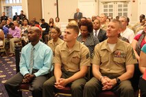 Graduates listen to Marc Cole, a former active-duty Marine and a acquisition and procurement advisor at the Consumer Financial Protection Bureau, keynote speech during the Voluntary Education Center’s graduation celebration ceremony at the Clubs at Quantico on July 24. 