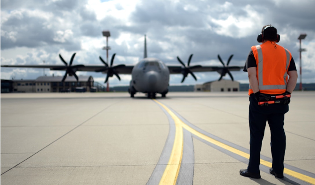 A member of the 726th Air Mobility Squadron waits to marshal a C-130 Hercules on the flightline Aug. 9, 2014, at Spangdahlem Air Base, Germany. Airmen from Spangdahlem AB will be supporting a bilateral training event with the Hellenic air force Aug. 11-23. The training aims to increase the military compatibility between the U.S. and Greece while sustaining capability to secure peace and stability in Europe. (U.S. Air Force photo/Staff Sgt. Daryl Knee) 