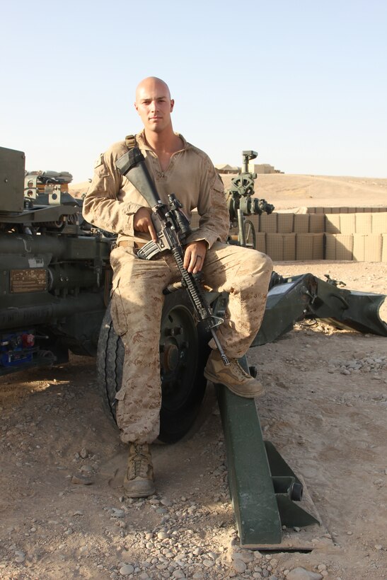 Corporal Shane Byram, a native of Sacramento, California and towed artillery system technician with Tango Battery, 5th Battalion, 11th Marine Regiment, poses for a photo next to a M777 howitzer aboard Camp Bastion, Helmand province, Afghanistan, July 21, 2014. Tango Battery has been vital to safeguarding the remaining U.S. and coalition forces in the region during 2014.
