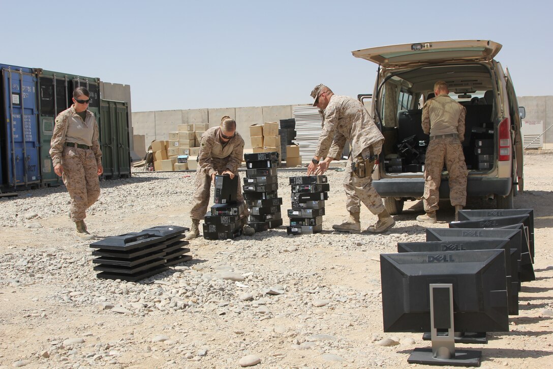 Sergeant Andrea M. Robb, center, the Theater Provided Equipment clerk with Marine Expeditionary Brigade - Afghanistan, inventories computer equipment from a unit with Regional Command (Southwest) as part of the retrograding efforts. Robb is responsible for a $28 million account and oversees approximately 8,500 pieces of equipment needing to be retrograded back to the States.