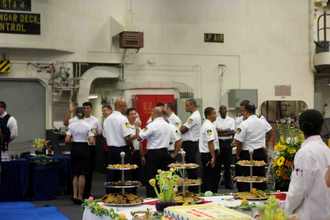 Members of the Brazilian Navy band socialize during a reception in the hangar bay of the future amphibious assault ship USS America (LHA 6) at Rio De Janeiro, Brazil, Aug. 7, 2014. The reception was hosted by the Sailors and Marines of America and Special Purpose Marine Air Ground Task Force South for Brazilian diplomats and military officials. The evening of food, music and dancing concluded with speeches from Rear Adm. Frank L. Ponds, commander of Expeditionary Strike Group 3 and The Honorable Liliana Ayalde, U.S. Ambassador to Brazil. America is currently on her maiden transit, “America Visits the Americas”. The transit is a clear example of our Nation’s commitment to our regional partners and allies, demonstrating the Navy-Marine Corps integration in action. (U.S. Marine Corps photo by 1st Lt. Joshua Pena/Released)