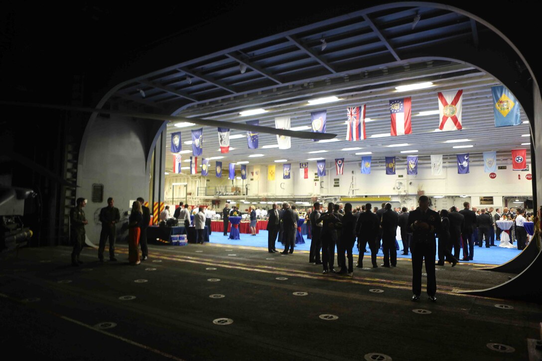 The lights from the hangar bay of the future amphibious assault ship USS America (LHA 6) shine brightly during a reception at Rio De Janeiro, Brazil, Aug. 7, 2014. The reception was hosted by the Sailors and Marines of America and Special Purpose Marine Air Ground Task Force South for Brazilian diplomats and military officials. The evening of food, music and dancing concluded with speeches from Rear Adm. Frank L. Ponds, commander of Expeditionary Strike Group 3 and The Honorable Liliana Ayalde, U.S. Ambassador to Brazil. America is currently on her maiden transit, “America Visits the Americas”. The transit is a clear example of our Nation’s commitment to our regional partners and allies, demonstrating the Navy-Marine Corps integration in action. (U.S. Marine Corps photo by 1st Lt. Joshua Pena/Released)