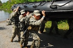 New York Army National Guard Soldiers of C Troop 2nd Squadron 101st Cavalry move their boats inland after crossing Indian Lake  in Zodiac inflatable boats during an annual training exercise here on Aug. 10, 2014. The Soldiers are the dismounted troop for the squadron - which serves as the eyes and ears of the 27th Infantry Brigade Combat Team - and need to hone their skills at conducting reconnaissance across rivers and lakes.