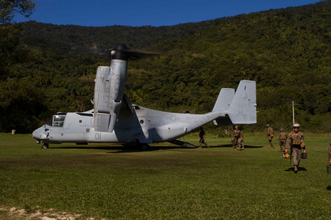 U.S. Marines and Sailors with Special Purpose Marine Air Ground Task Force South exit an MV-22 Osprey after being inserted at Marambaia Island, Brazil, Aug. 4, 2014. The SPMAGTF personnel, arriving from the future amphibious assault ship USS America (LHA 6), came to the island to participate in a theater security cooperation event with Brazilian Naval forces. The TSC event is made up to include multiple bi-lateral exchanges of medical treatment, improvised explosive device detection, combat tracking and combat marksmanship. Through close cooperation, the U.S. and its partners are ready to address transnational security challenges through integrated and coordinated approaches. SPMAGTF-South is currently embarked aboard the future amphibious assault ship USS America (LHA 6) in support of her maiden transit, "America Visits the Americas." (U.S. Marine Corps Photo by Cpl. Donald Holbert/ Released)