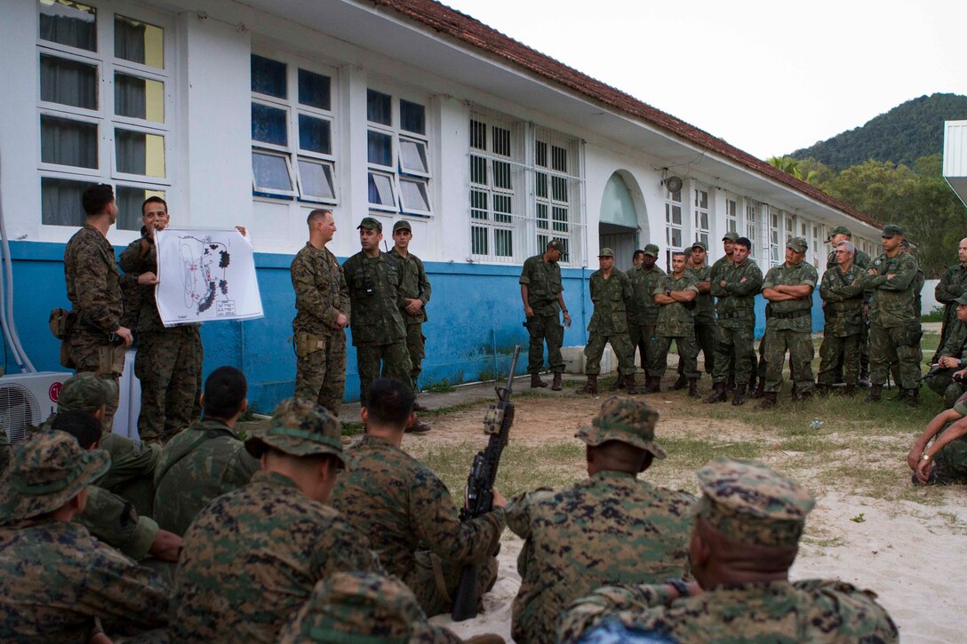 U.S. Marines with Special Purpose Marine Air Ground Task Force South share experiences of warfighting tactics with Brazilian Naval forces at Marambaia Island, Brazil, Aug. 4, 2014, as part of a theater security cooperation event. The TSC event was made up of multiple bi-lateral exchanges to include medical treatment, improvised explosive device detection, combat tracking and combat marksmanship. Through close cooperation, the U.S. and its partners are ready to address transnational security challenges through integrated and coordinated approaches. SPMAGTF-South is currently embarked aboard the future amphibious assault ship USS America (LHA 6) in support of her maiden transit, "America Visits the Americas." (U.S. Marine Corps Photo by Cpl. Donald Holbert/ Released)