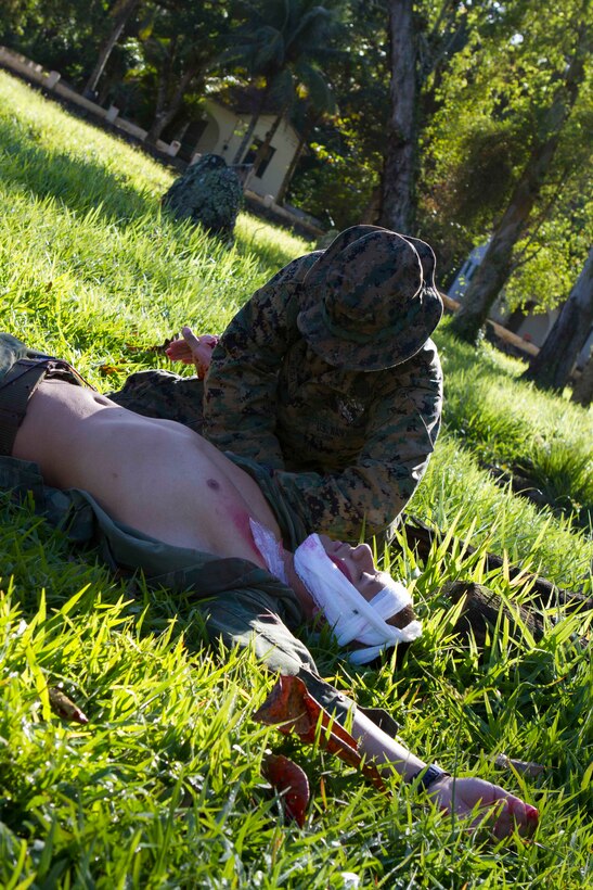 Petty Officer 2nd Class Gabriel Besa, U.S. Navy hospital corpsman with Special Purpose Marine Air Ground Task Force South, and a native of Pearland, Texas, provides emergency medical care to a simulated casualty during a bi-lateral medical exchange with Brazilian Naval forces at Marambaia Island, Brazil, Aug. 6, 2014. During the exchange, U.S. Marines and Sailors had the opportunity to share tactics from their Combat Lifesaver course as part of a theater security cooperation event with the Logistics Combat Element of SPMAGTF-South. Through close cooperation, the U.S. and its partners are ready to address transnational security challenges through integrated and coordinated approaches. SPMAGTF-South is currently embarked aboard the future amphibious assault ship USS America (LHA 6) in support of her maiden transit, "America Visits the Americas." (U.S. Marine Corps Photo by Cpl. Donald Holbert/ Released)