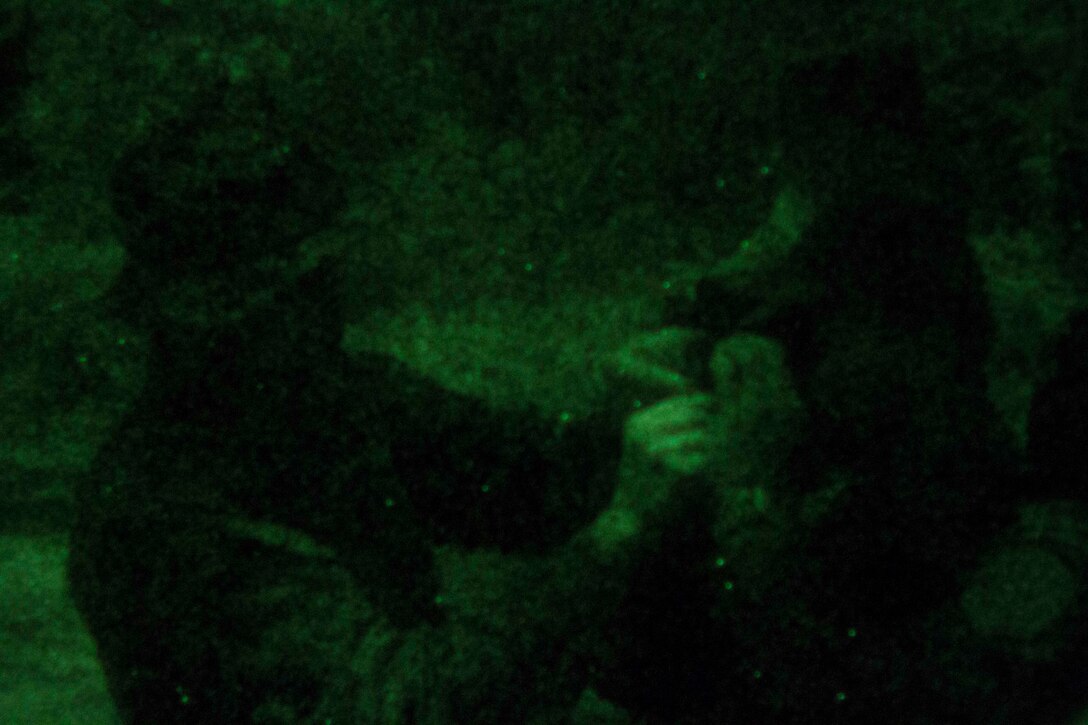 Sergeant Caleb Pente, explosive ordnance disposal technician with Special Purpose Marine Air Ground Task Force South, and a native of Detroit, shares with a Brazilian Marine about proper usage of night vision equipment during the night portion of a combat tracking class on Marambaia Island, Brazil, Aug. 5, 2014. The combat tracking was conducted conjunction with a counter improvised explosive device course as part of a theater security cooperation event with the Logistics Combat Element of SPMAGTF-South. Through close cooperation, the U.S. and its partners are ready to address transnational security challenges through integrated and coordinated approaches. SPMAGTF-South is currently embarked aboard the future amphibious assault ship USS America (LHA 6) in support of her maiden transit, "America Visits the Americas." (U.S. Marine Corps Photo by Cpl. Donald Holbert/ Released)