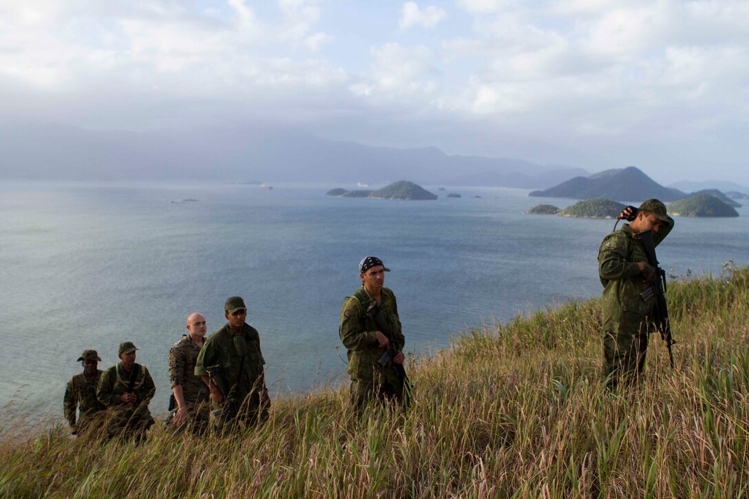 Brazilian Marines track a simulated enemy up a mountain during a bi-lateral combat tracking exchange held on Marambaia Island, Brazil, Aug. 5, 2014. During the exchange, Brazilian and U.S. Marines with Special Purpose Marine Air Ground Task Force South shared their tactics on tracking enemy personnel and how to spot hidden improvised explosive devices. Through close cooperation, the U.S. and its partners are ready to address transnational security challenges through integrated and coordinated approaches. SPMAGTF-South is currently embarked aboard the future amphibious assault ship USS America (LHA 6) in support of her maiden transit, "America visits the Americas." 