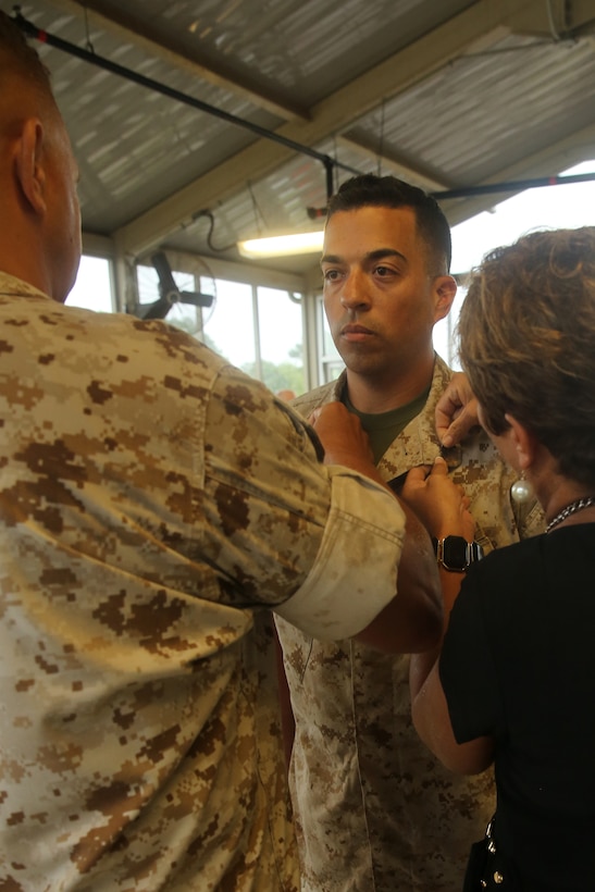 Lt. Col. Ernest Henderson, left, and Marlana Robles, right, promote Cpl. Robert Robles during a ceremony at Marine Corps Air Station Cherry Point, N.C., Aug. 5, 2014. Henderson, Robles’ uncle, acted as the promoting officer during the ceremony, his last official duty before retirement. Marlana, a retired Marine and former drill instructor, encouraged her son
 to join the Marine Corps at age 28. Robles is a third-generation Marine with a family history of Marine Corps service stretching back to the 1950s. Robles is a military policeman with Cherry Point’s Provost Marshals Office. 
