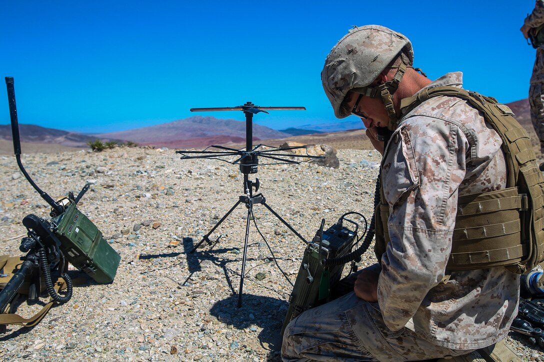 Corporal Ryan Schalles from Lubbock, Texas, a proffesionally instructed gunman and rifleman with 1st Battalion, 1st Marine Regiment, 1st Marine Expeditionary Brigade, sets up communication via radio while conducting combined arms training in support of Large Scale Exercise 2014 aboard Marine Corps Air Ground Combat Center Twentynine Palms, Calif., Aug. 9. LSE-14 is a bilateral training exercise being conducted by 1st MEB to build U.S. and Canadian forces’ joint capabilities through live, simulated, and constructive military training activities from Aug. 8-14, 2014. (U.S. Marine Corps Photo by Cpl. Rick Hurtado/Released)