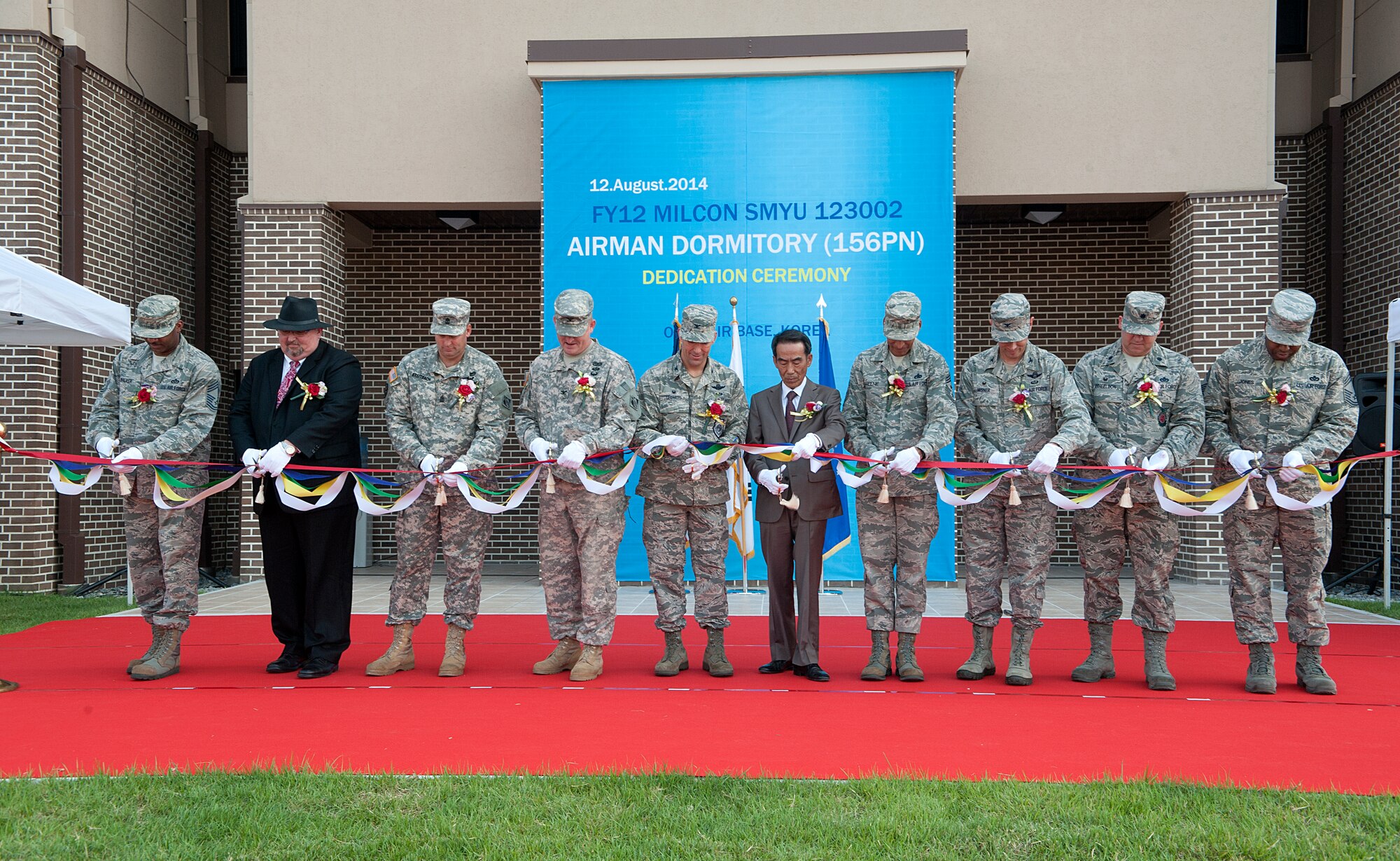 Osan Air Base leadership and Mr. Kwak Sun Ki, Seohee Construction Company president, cut a ribbon during the opening of dormitory 1459 at Osan AB, Republic of Korea, Aug. 12, 2014. The new dormitory will house 156 permanently stationed personnel at Osan AB. The dormitory living areas consist of four person suites, lounge, restrooms in each dorm room, public restrooms, bulk storage, and mechanical rooms.