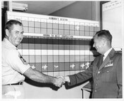 C-119 31 Jan 1961 - 19 Dec 1962; Left to Right, #1 CMSgt James "Jim" Horton, #2 BG William J. Payne with Aircraft Status in Background (Photo by NCANG Heritage Program)