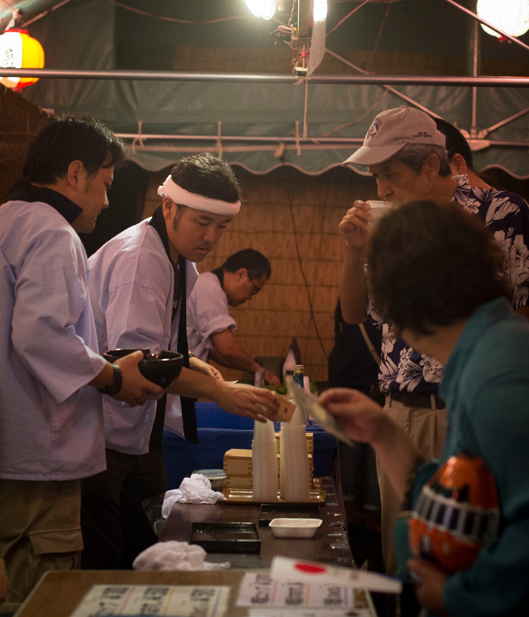 Sake vendors prepare drinks at the Fussa Tanabata Festival in Fussa City, Japan, Aug. 8, 2013. Tanabata is the Japanese star festival originating from the Chinese Qixi Festival, celebrating the meeting of the stars Vega and Altair. (U.S. Air Force photo by Airman 1st Class Meagan Schutter/Released)