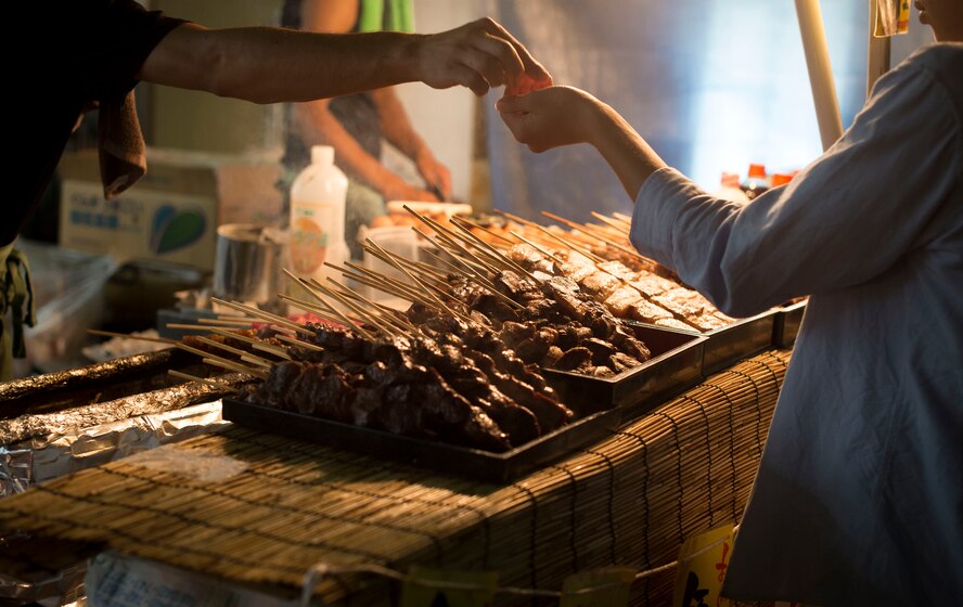 A street vendor hands change back to a customer at the Fussa Tanabata Festival in Fussa City, Japan, Aug. 8, 2013. Vendors featuring a variety of foods lined the streets for festival participants to enjoy. (U.S. Air Force photo by Airman 1st Class Meagan Schutter/Released)