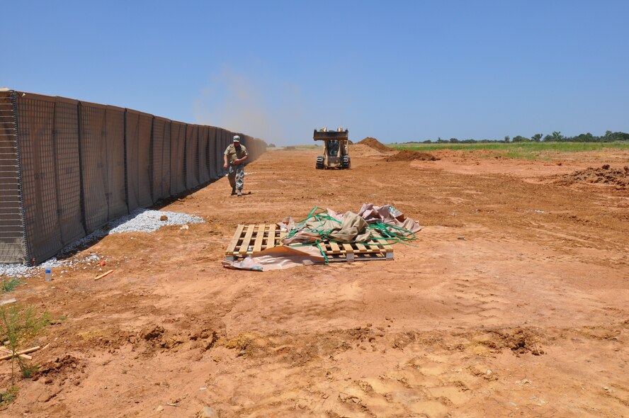 Senior Master Sgt. Danny Jones, 301st Civil Engineer Squadron electrical superintendent, walks next to dirt barriersJuly 12, 2014, at Fort Wolters. Members of the 301 CES helped construct a five-acre Forward Operating Base in a joint effort with the Texas Army National Guard’s 176th Engineering Brigade. (U.S. Air Force photo by Master Sgt. Mark Orr)