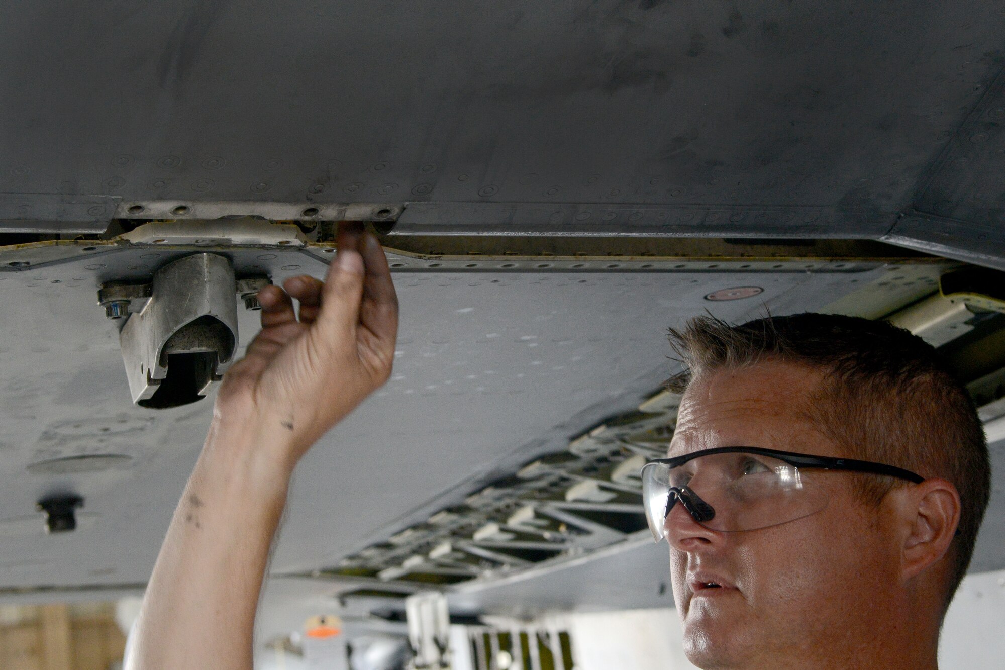 U.S. Air Force Tech. Sgt. Robert Coursey, 20th Equipment Maintenance Squadron inspection section dock chief inspects an F-16CM Fighting Falcon aircraft wing after helping re-attach it at Shaw Air Force Base, S.C., Aug. 6, 2014. The aircraft rely on the wings for maneuverability and distance it can fly to enter air combat, stay, fight and return. (U.S. Air Force photo by Senior Airman Ashley Gardner/Released)