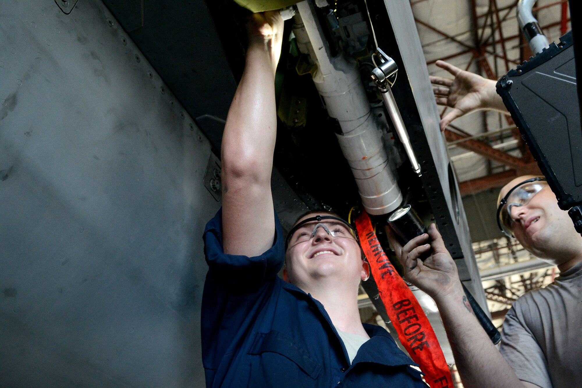 U.S. Air Force Airman 1st Class Elden Ball, 20th Equipment Maintenance Squadron phase inspection team member and Staff Sgt. Paul Stevens, 20th EMS floor chief work together to repair an F-16CM Fighting Falcon before re-attaching the left wing at Shaw Air Force Base, S.C., Aug. 6, 2014. The 19,700-pound aircraft has a wingspan of 32-feet and eight-inches. (U.S. Air Force photo by Senior Airman Ashley Gardner/Released)