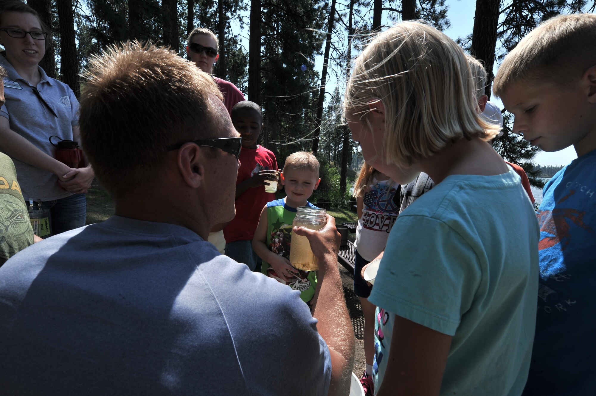 Tech. Sgt. Kyle Oler explains the importance of purifying natural water before drinking to children from the Fairchild Air Force Base Youth Center at Clear Lake, Washington, Aug. 6, 2014. Oler is a member of the 22nd Training Squadron. Children from age’s five to 12 were given the opportunity to work on several exercises to teach them how to procure water, fire safety, and navigation and camouflage from members of the 22nd Training Squadron. (U.S. Air Force photo by Staff Sgt. Alexandre Montes/Released)    