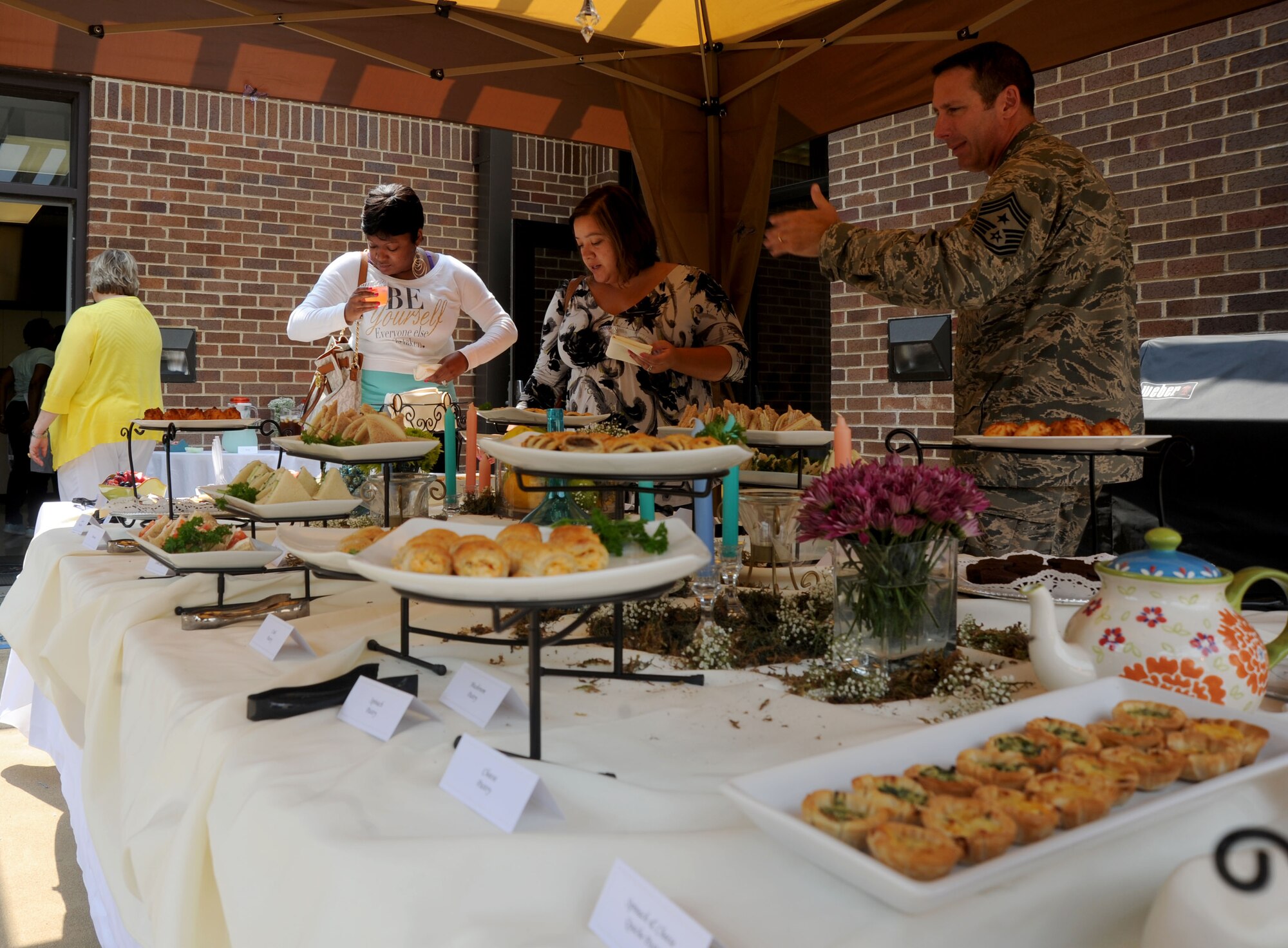 Members of Team Andrews gather around the food after a Heart Link event at the Military & Family Support Center here, August 9, 2014. (U.S. Air Force photo/Airman 1st Class Ryan J. Sonnier)