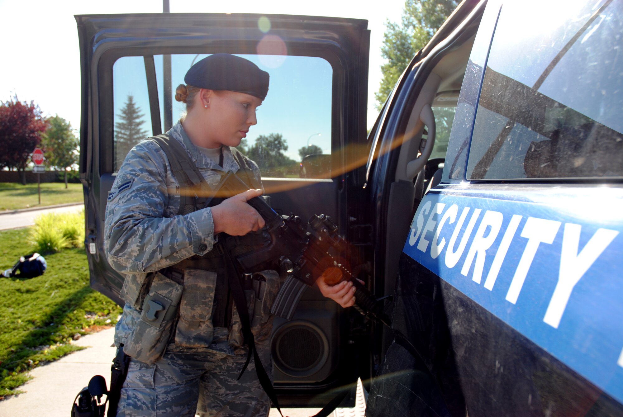Airman 1st Class Ashley Miller, 319th Security Forces Squadron installation entry controller, secures her M-4 assault rifle in a patrol car prior to traveling to another post during her shift on Aug. 11, 2014, at Grand Forks Air Force, N.D.  Security Forces members receive small arms training during technical school at Lackland Air Force Base, Texas. (U.S. Air Force photo/Staff Sgt. Luis Loza Gutierrez)
