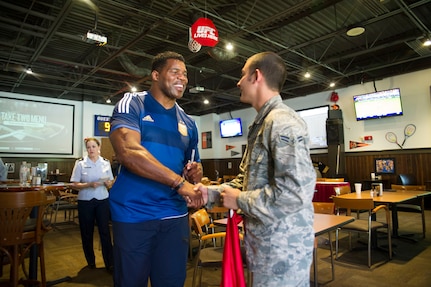 Heisman Trophy winner and former NFL star Herschel Walker meets with Airman 1st Class Casey Cooper, 628th Civil Engineer Squadron, during a meet and greet/autograph session at Rookies in the Charleston Club, Aug. 6, 2014, at Joint Base Charleston, S.C. Walker visited the base to share his story about growing up in Georgia, playing professional football and how he sought help from mental health professionals for his struggles with dissociative identity disorder. Walker spoke and met Sailors and Airmen at both the Weapons Station and Air Base where he met with service members and their families and signed autographs. Walker played college football at the University of Georgia and spent 14 years in the NFL. (U.S. Air Force photo/Staff Sgt. William O’Brien) 