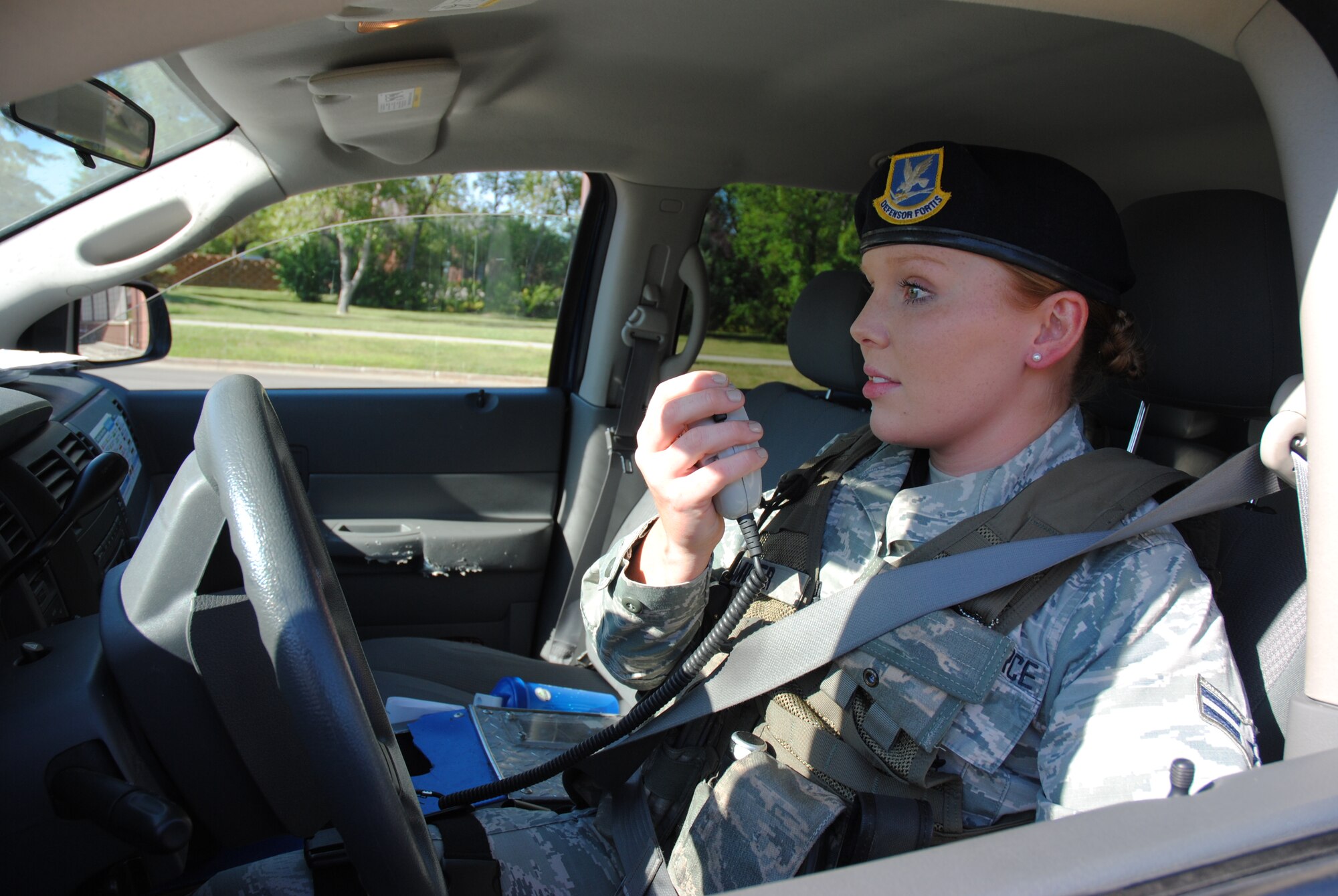 Airman 1st Class Ashley Miller, 319th Security Forces Squadron installation entry controller, uses the radio in a patrol car to communicate her current location to the law enforcement dispatch center while on patrol on Aug. 11, 2014, on Grand Forks Air Force, N.D. Miller is also a member of the Internal Security Response Team, which has the primary duty of protecting assets on a flightline such as aircraft. (U.S. Air Force photo/Staff Sgt. Luis Loza Gutierrez)
