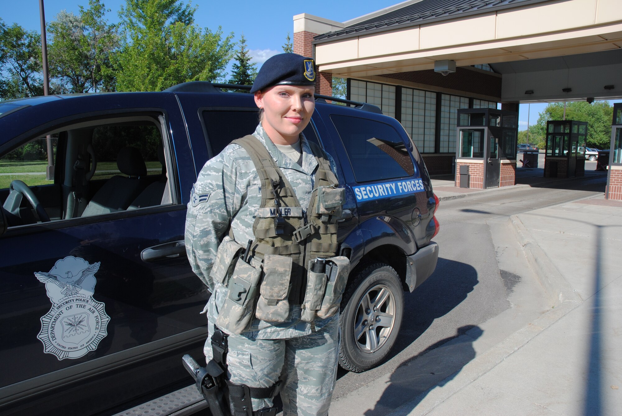 Airman 1st Class Ashley Miller, 319th Security Forces Squadron installation entry controller, poses for a photo near the main gate of Grand Forks Air Force, N.D. The Monterey, Tenn., native was chosen as the Grand Forks AFB Warrior of the Week for the second week of August 2014.  (U.S. Air Force photo/Staff Sgt. Luis Loza Gutierrez)
