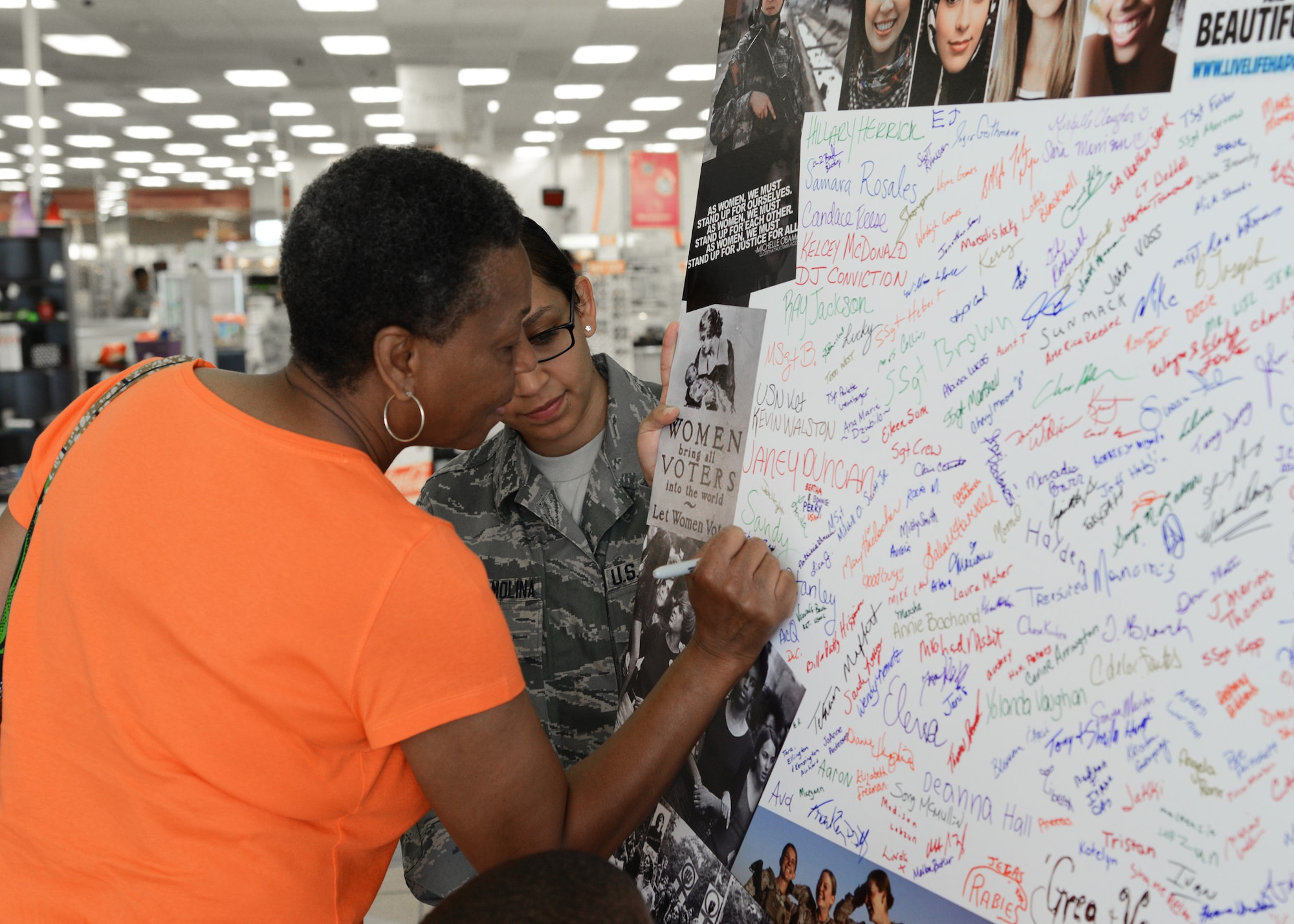 Sharon Bellamy signs the Joint Base Langley-Eustis Women’s Equality Wall in the Exchange atrium at Langley Air Force Base, Va., Aug. 12, 2014. Guests who donate $1 or more can sign the wall in honor of women who have inspired them. Proceeds from donations, collected by the JBLE Women’s Equality Committee, will benefit local women’s and children’s shelters. (U.S. Air Force photo by Senior Airman Jason J. Brown/Released)