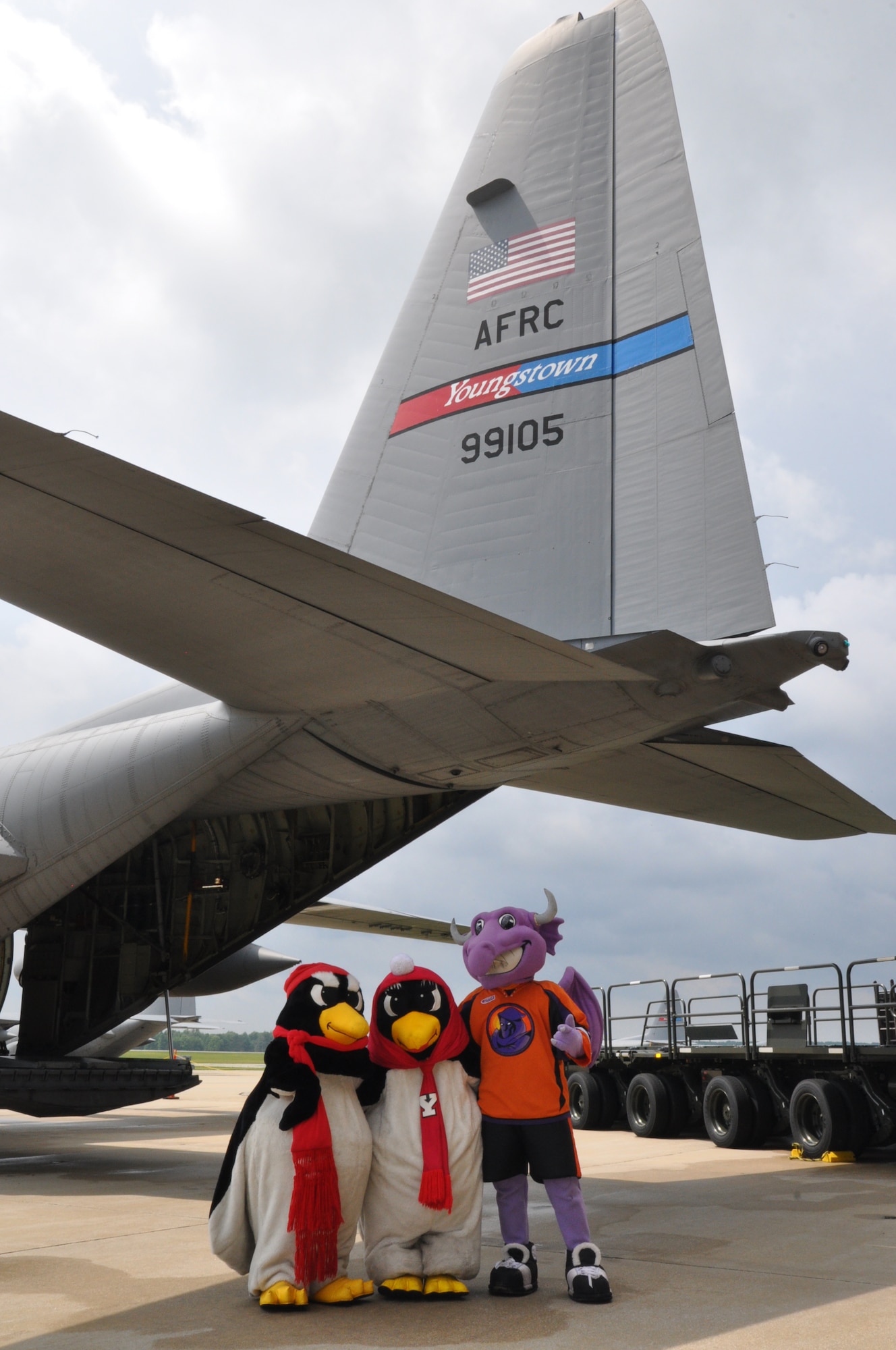 YOUNGSTOWN AIR RESERVE STATION, Ohio – Youngstown State University mascots Pete and Penny Penguin as well as Youngstown Phantoms mascot Sparky stand in front of an Air Force Reserve C-130 Hercules aircraft, assigned to the 910th Airlift Wing based here, on the flightline during the wing’s recent Family Day held here, August 3, 2014. Family day is an installation open house held for 910th Servicemembers and their families, designed to let Reserve families strengthen bonds and experience the home station of their Reservist loved one. The mascots were on hand to promote upcoming 910th community events with YSU’s 1-AA football team and the United States Hockey League’s Phantoms team. U.S. Air Force photo by Master Sgt. Bob Barko Jr.