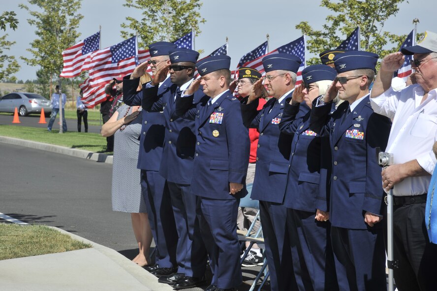 Members of Team Fairchild leadership render a salute during the singing of the National Anthem during the 4th annual Missing in America Interment Service at the Washington State Veterans Cemetery in Medical Lake, Washington, Aug. 8, 2014. During the ceremony, 44 service men and women, once forgotten and never claimed, were laid to rest after working with Patriot Guard Riders, local medical examiners, coroners and funeral homes. (U.S. Air Force photo by Senior Airman Mary O'Dell/Released)