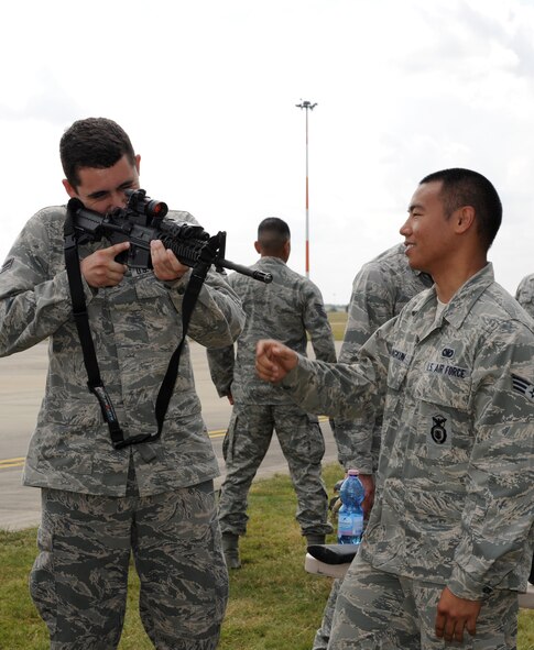 U.S. Air Force Senior Airman Keeling Weber, left, 352nd Special Operations Support Squadron, looks through he scope of an M4 carbine, while U.S. Air Force Senior Airman Radit Jirangkun, 352nd SOSS deployed aircraft ground response element operator explains the weapon's capabilities during the Introduction to Special Operations Group event, Aug. 7, 2014, outside building 550 on RAF Mildenhall, England. The ISOG event is a class for those new to the 352nd Special Operations Group. Attendees were briefed by all the different elements that comprise 352nd SOG as well as see several aerial platforms and ground equipment special operations forces uses. (U.S. Air Force photo/Tech. Sgt. Stacia Zachary/Released)