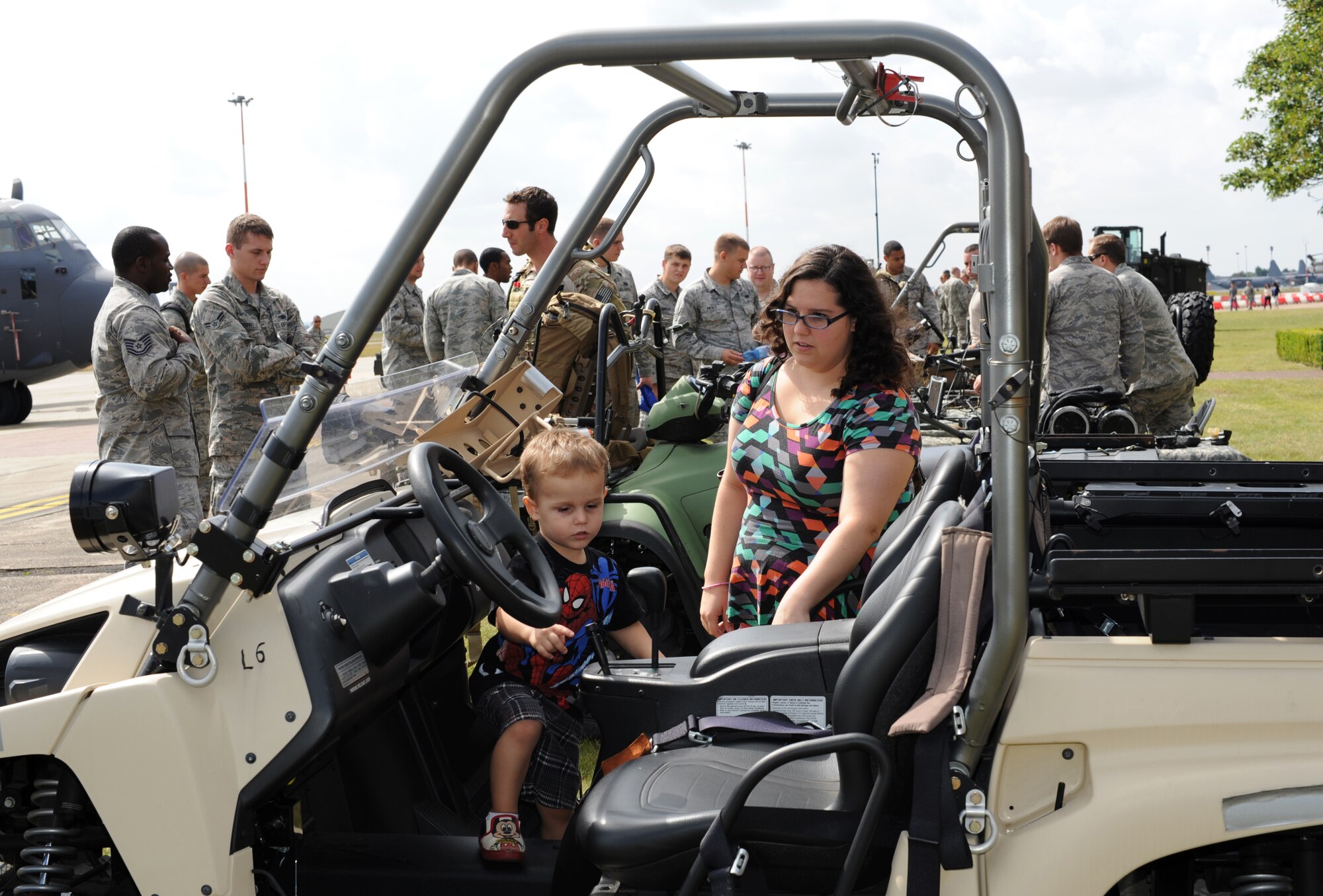 Taylor Bone, right, wife of Senior Airman D Mathieu Bone, 352nd Special Operations Maintenance Squadron, watches as her son Orion, 2, climbs into a lightweight tactical all-terrain vehicle during the Introduction to Special Operations Group event Aug. 7, 2014, outside building 550 on RAF Mildenhall, England. The ISOG event is a class for those new to the 352nd Special Operations Group. Attendees were briefed by all the different elements that comprise 352nd SOG as well as see several aerial platforms and ground equipment special operations forces uses. (U.S. Air Force photo/Tech. Sgt. Stacia Zachary/Released)