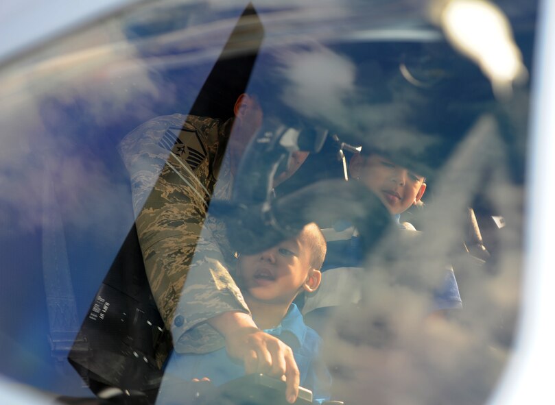 A father shows his sons the inside the flight deck of the CV-22 Osprey during the Introduction to Special Operations Group event Aug. 7, 2014, outside building 550 on RAF Mildenhall, England. The CV-22 is a tiltrotor aircraft that cobines the vertical takeoff, hover and vertical landing qualities of a helicpter with the long-range, fuel-efficiency and speed characteristics of a turbo-prop aircraft. Attendees were briefed by all the different elements that comprise 352nd SOG as well as see several aerial platforms and ground equipment special operations forces uses. (U.S. Air Force photo/Tech. Sgt. Stacia Zachary/Released)