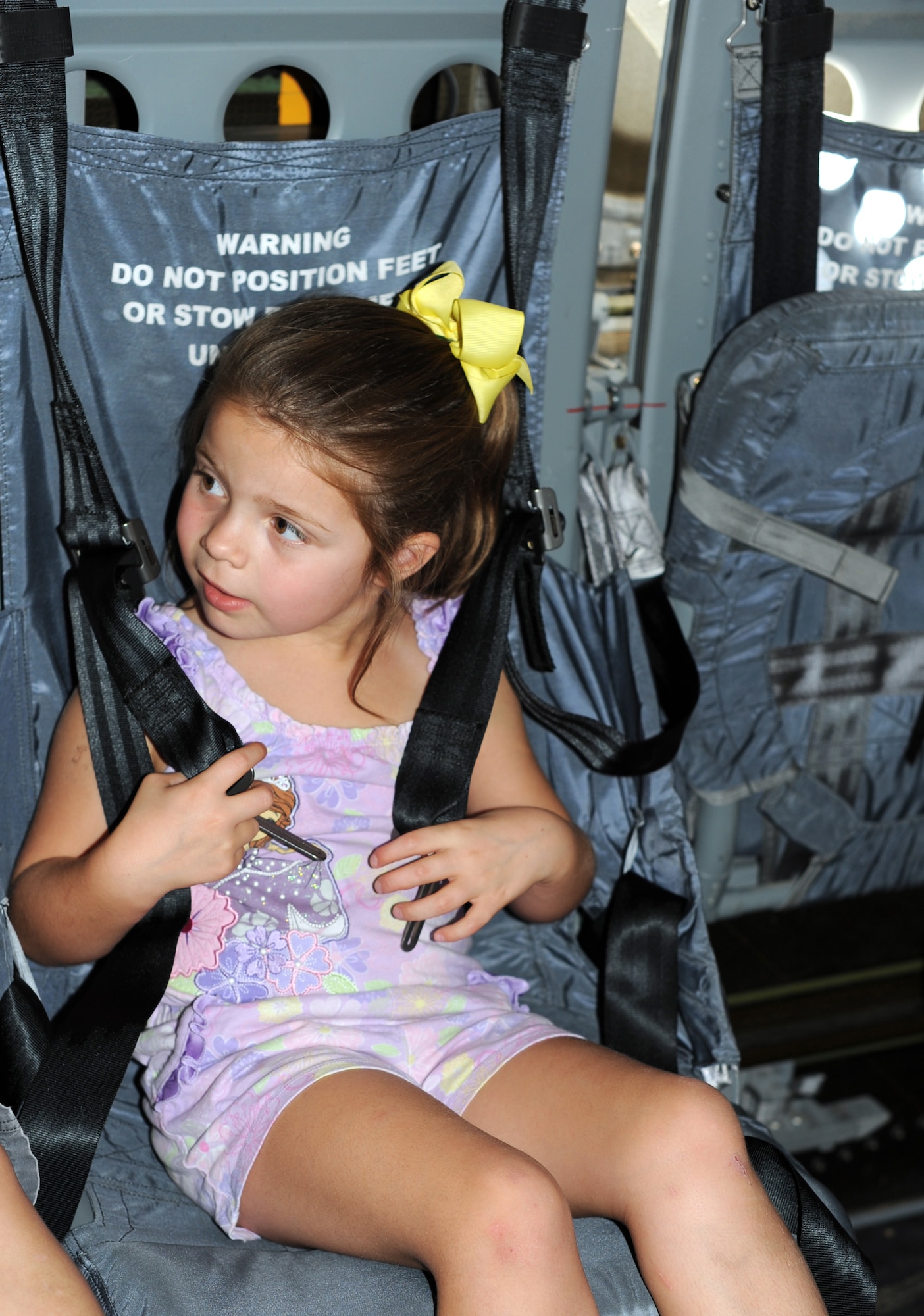 Sophie, 5, daughter of U.S. Air Force 1st Lt. Nick Collazo, 352nd Special Operations Maintenance Squadron, straps herself into a seat inside the back of a CV-22 Osprey during the Introduction to Special Operations Group event Aug. 7, 2014, outside building 550 on RAF Mildenhall, England. Active-duty members and their family were treated to an inside look of the different aerial and weapons platforms used here. Attendees were briefed by all the different elements that comprise 352nd SOG as well as see several aerial platforms and ground equipment special operations forces uses. (U.S. Air Force photo/Tech. Sgt. Stacia Zachary/Released)