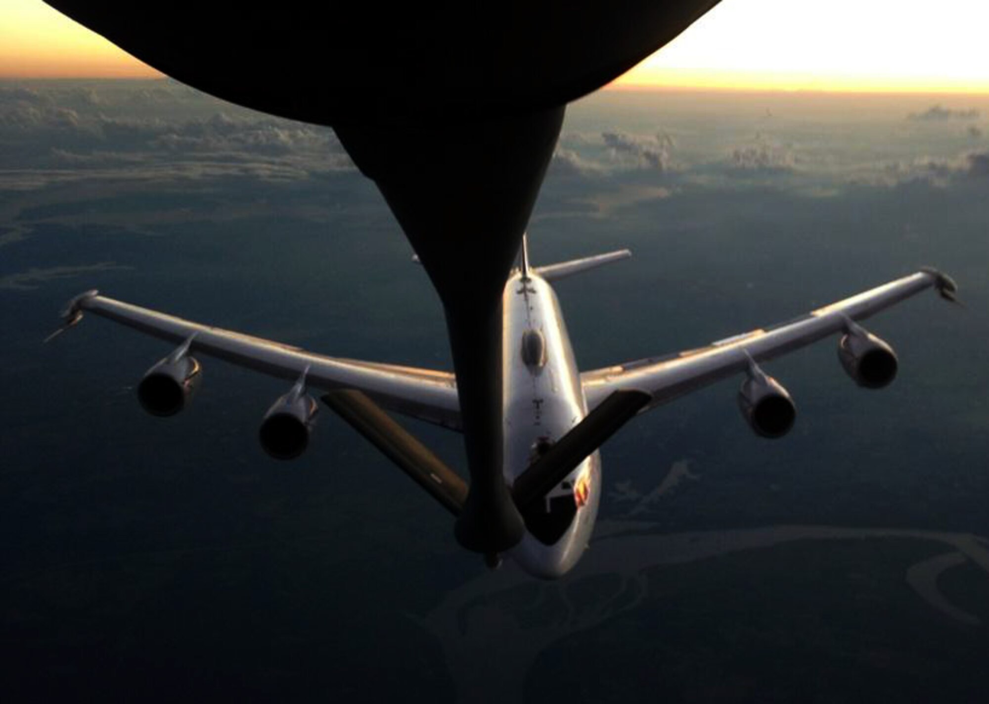 A U.S. Navy E-6B Mercury aircraft approaches the refueling boom of a KC-135 Stratotanker assigned to McConnell Air Force Base, Kan., during an evening air refueling mission, Aug. 11, 2014.  The KC-135 was operated by an aircrew made up of Air Force Reservists from the 931st Air Refueling Group at McConnell AFB.  (U.S. Air Force photo by Senior Master Sgt. Ray Lewis)    