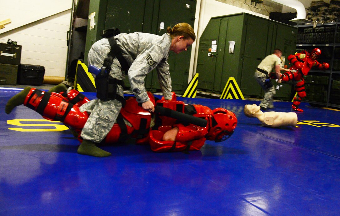 WRIGHT-PATTERSON AIR FORCE BASE, Ohio - Staff Sgt. Dawn Gettys and Senior Airman Kyle Altman, both ssigned to the 445th Security Forces Squadron, practice subduing perpetrators during the use of force training, July 13, 2014 here. The 445 SFS conducts training through a scenario-based course on de-escalating conflict by using verbal commands, simulating use of pepper spray, batons or deadly force. The annual training ensures the squadron is proficient and maintains operational readiness. (U.S. Air Force photo/Senior Airman Devin Long)