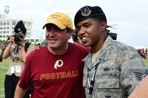 U.S. Air Force Staff Sgt. Lenton Luss, 633rd Security Forces Squadron base defense operations center controller, meets Dan Snyder, Washington Redskins owner, during a training camp practice in Richmond, Va., Aug. 11, 2014. Snyder, along with the team’s general manager, Bruce Allen, thanked the military members in attendance for their service to the nation. (U.S. Air Force photo by Senior Airman Aubrey White/released) 