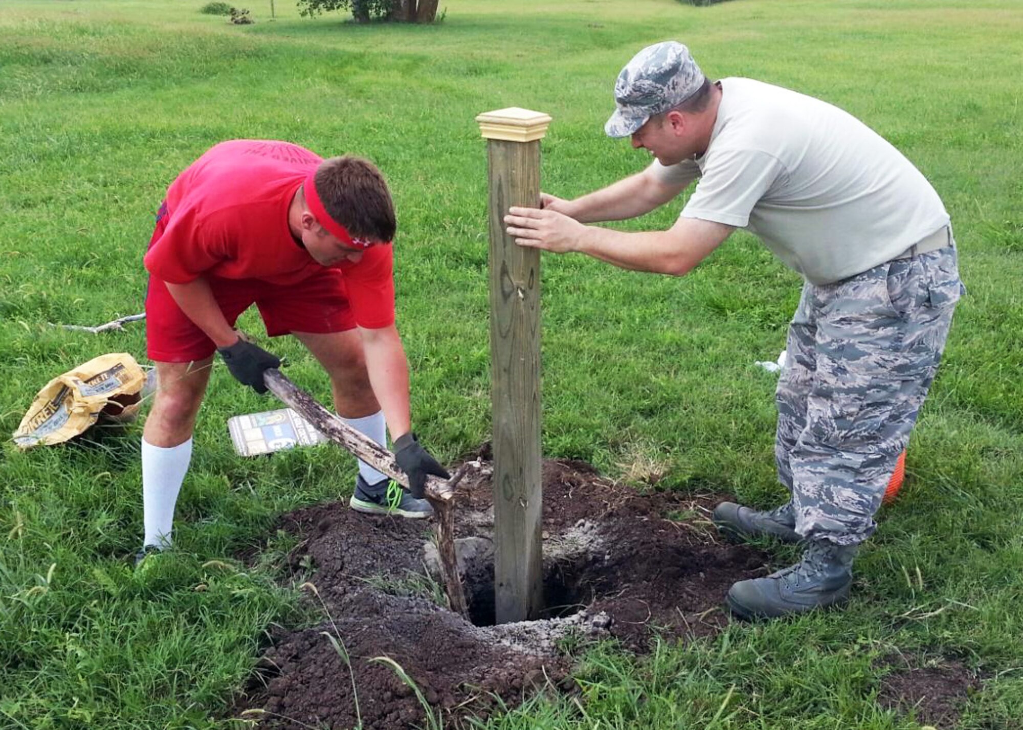 Senior Airman Matthew Stewart and Master Sgt. John Giamello, 931st Maintenance Squadron, work together to dig a hole for the placement of a par sign for a new disc golf course at McConnell Air Force Base, Kan., Aug. 11, 2014.  A collection of volunteers from the 931st Air Refueling Group gave of their time to complete a disc golf course, which was started as a volunteer project by Taylor Stephenson, the son of 931 ARG member Johnny Stephenson. Taylor has been working to design and install a new disc golf course on base as part of his Eagle Scout project through the Boys Scouts organization. The new, completed course features nine new disc golf holes with improved regulation tee boxes. (U.S. Air Force photo by Johnny Stephenson)