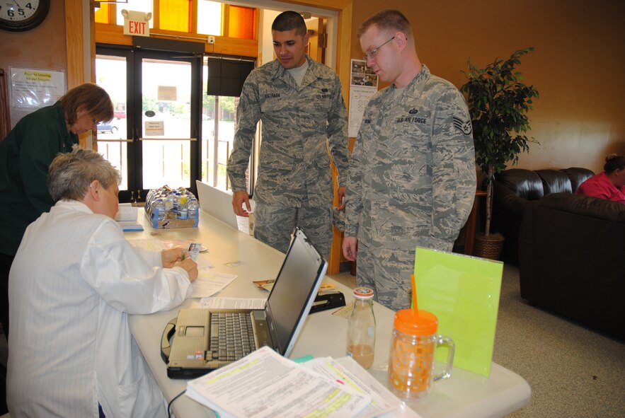 Senior Airman Maximiliano Estrada and Staff Sgt. Christopher Young from the 319th Force Support Squadron sign up to save lives by each making a blood donation Aug. 6, 2014, at Sven’s Den on Grand Forks Air Force Base, N.D.  Sixty-five blood units were netted during the drive coordinated by the 319th Medical Group and the DAK-MINN Blood Bank. (U.S. Air Force photo/Staff Sgt. Luis Loza Gutierrez)